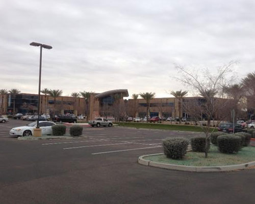 parking lot with office building in background